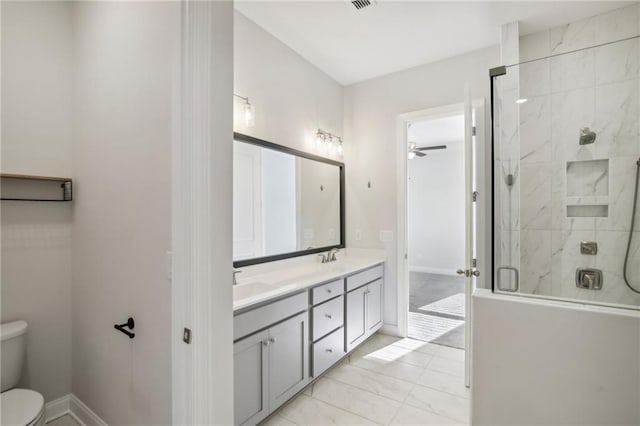 bathroom with ceiling fan, vanity, a shower with door, and toilet