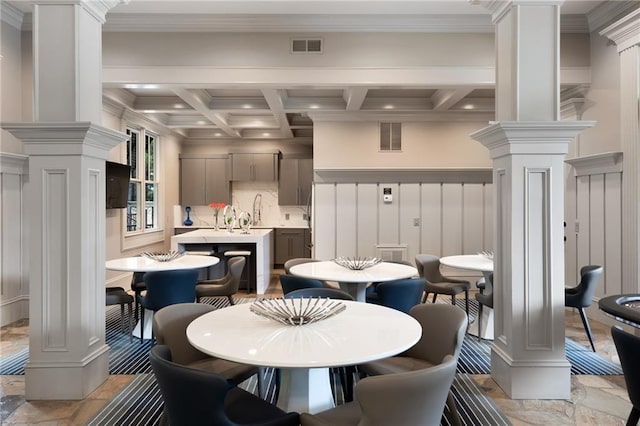 dining room featuring coffered ceiling, ornate columns, beamed ceiling, and crown molding