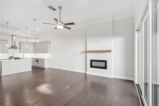 671 Stickley Oak Way, Woodstock, GA 30189 - unfurnished living room with ceiling fan, dark wood finished floors, ornamental molding, baseboards, and a glass covered fireplace