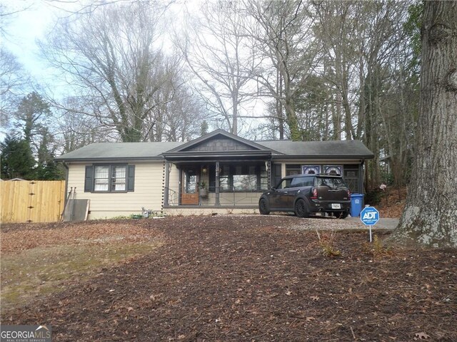 view of front of property with covered porch, an attached carport, fence, and a gate