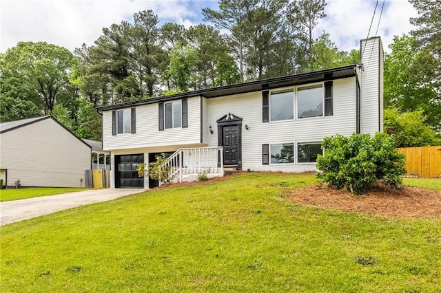 raised ranch with driveway, a chimney, a front yard, an attached garage, and fence