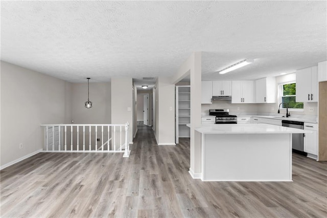 kitchen with light wood-style flooring, a textured ceiling, and appliances with stainless steel finishes