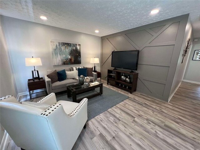 living room with a textured ceiling and light hardwood / wood-style floors