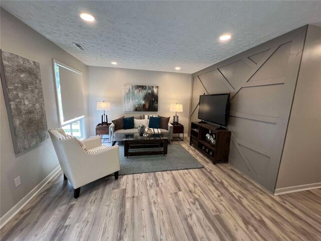 living room featuring a textured ceiling and hardwood / wood-style flooring