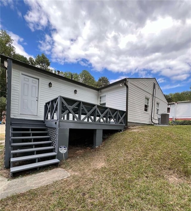 view of property exterior with central air condition unit and a yard