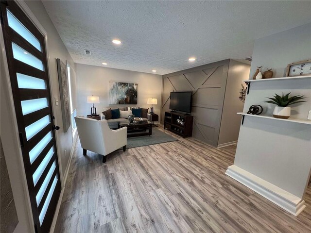 living room featuring a textured ceiling and hardwood / wood-style flooring