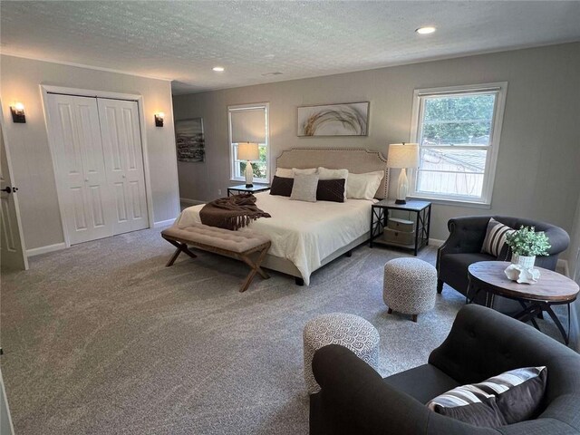 bedroom with a closet, carpet floors, and a textured ceiling