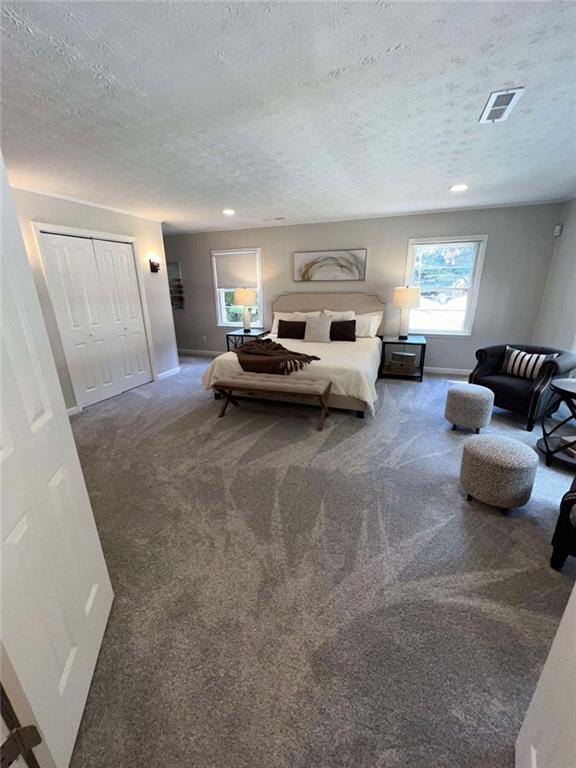 carpeted bedroom featuring a textured ceiling and a closet