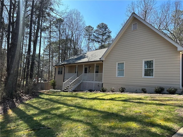 rear view of house with a lawn and a porch