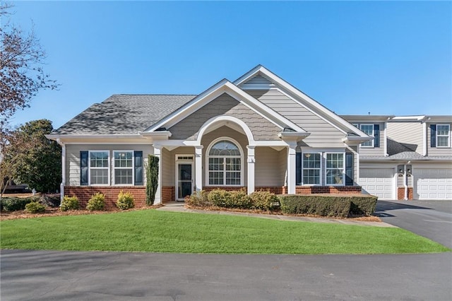 craftsman-style home featuring a garage and a front lawn