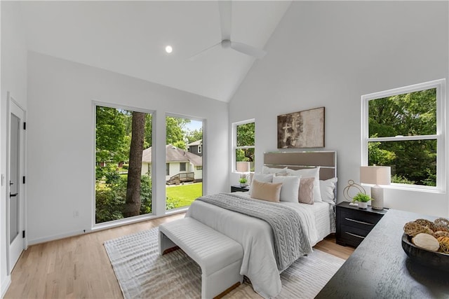 bedroom featuring light wood-type flooring and high vaulted ceiling