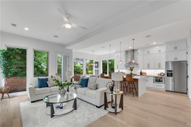 living room featuring light wood-type flooring and ceiling fan