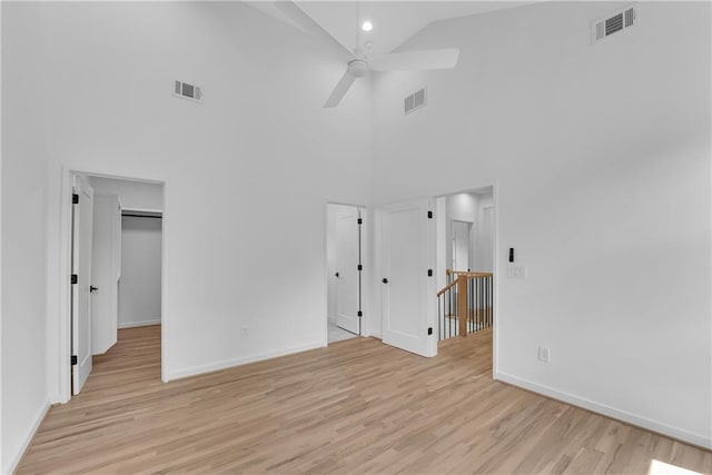 unfurnished room featuring light wood-type flooring, high vaulted ceiling, and ceiling fan