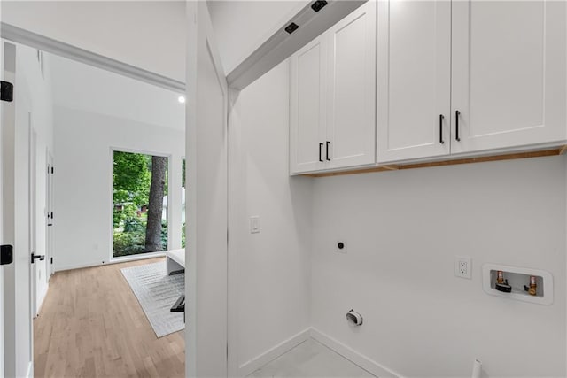 laundry room with washer hookup, cabinets, light wood-type flooring, and hookup for an electric dryer