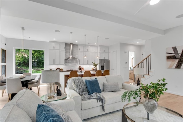 living room featuring sink and light hardwood / wood-style flooring