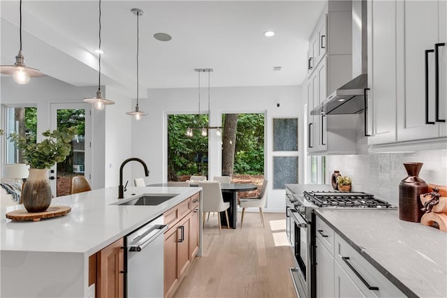 kitchen with appliances with stainless steel finishes, tasteful backsplash, sink, white cabinetry, and hanging light fixtures