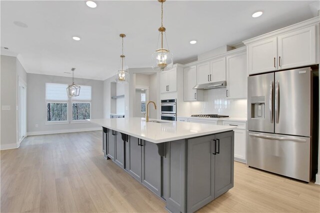 entryway with light wood finished floors, a tray ceiling, ornamental molding, baseboards, and stairs