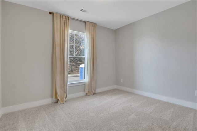 spare room with light carpet, visible vents, and baseboards