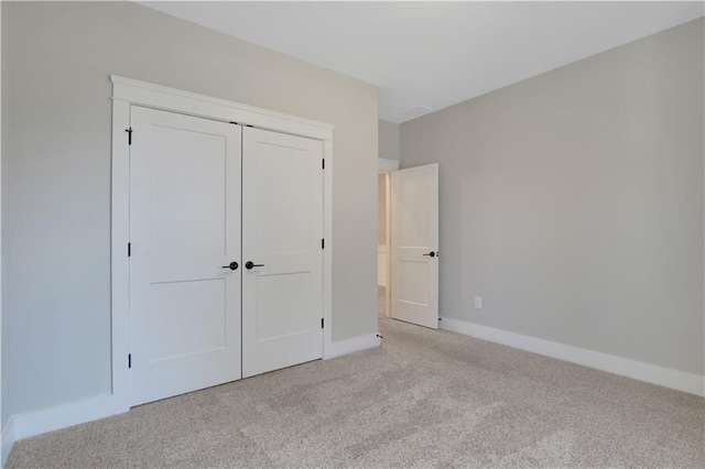 unfurnished bedroom with carpet floors, a closet, and baseboards