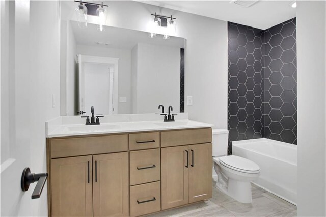 bathroom with a sink, double vanity, and toilet