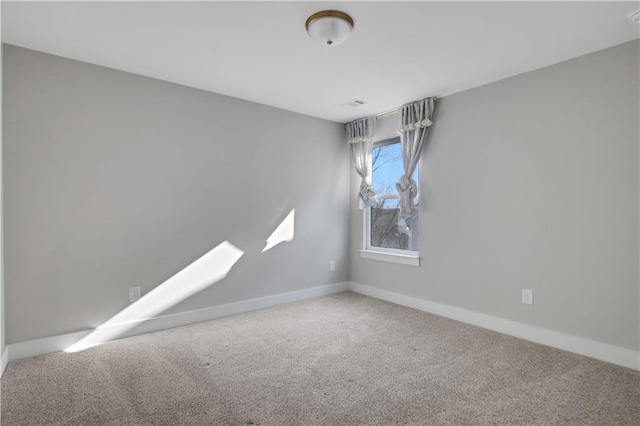 carpeted spare room with baseboards