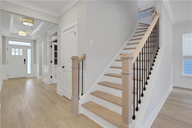 empty room featuring light wood finished floors, a tray ceiling, visible vents, baseboards, and ceiling fan