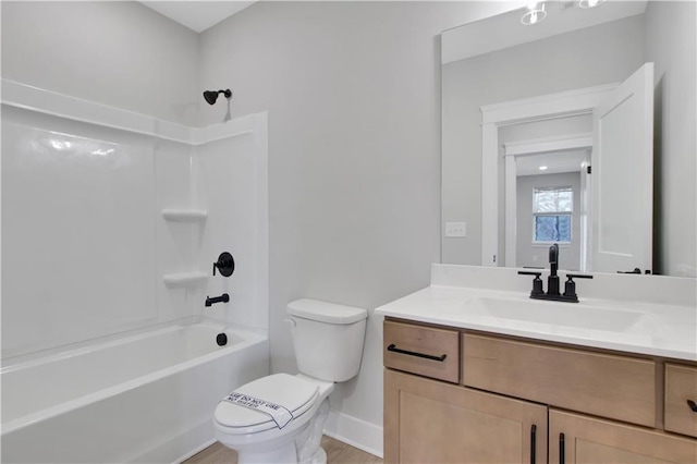 bathroom with baseboards, toilet, vanity, and shower / tub combination