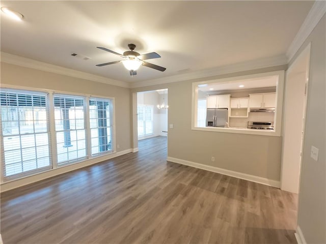 spare room with ceiling fan with notable chandelier, hardwood / wood-style flooring, and ornamental molding