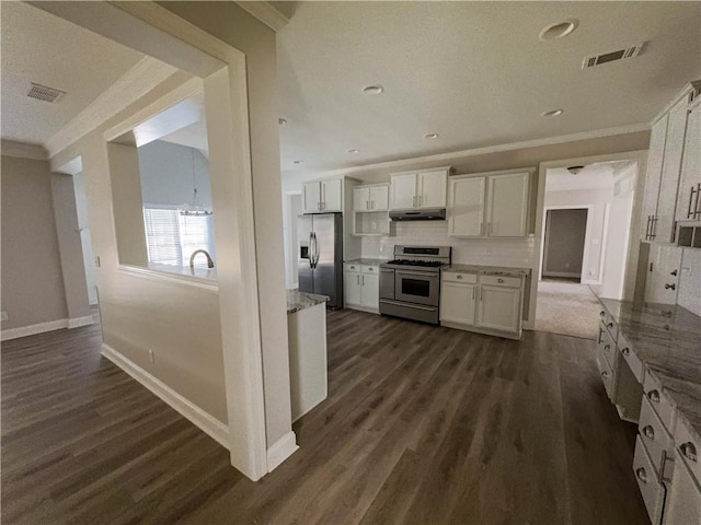 kitchen with appliances with stainless steel finishes, dark hardwood / wood-style flooring, white cabinetry, and crown molding