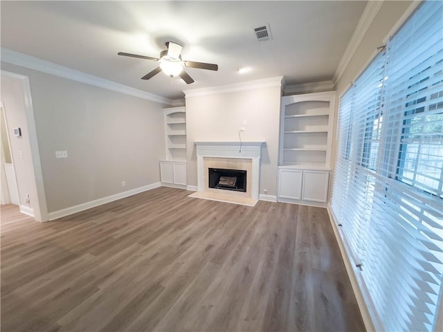 unfurnished living room featuring ceiling fan, hardwood / wood-style floors, built in features, and ornamental molding