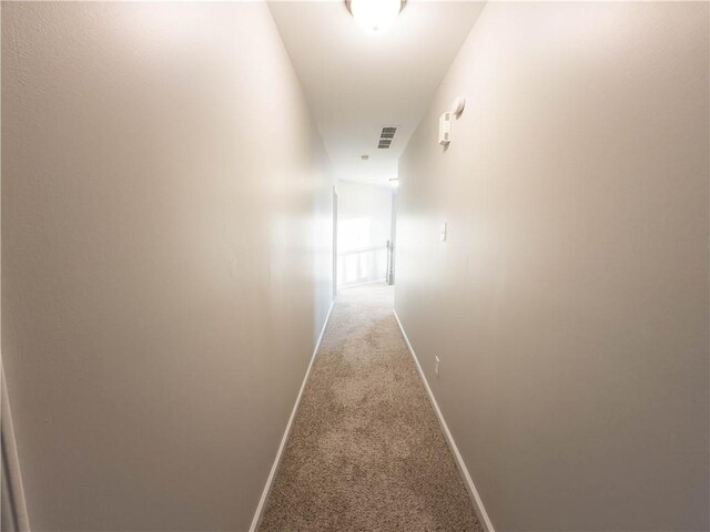 hall with light colored carpet