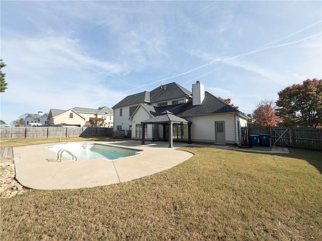 rear view of property with a gazebo, a yard, a patio, and a fenced in pool