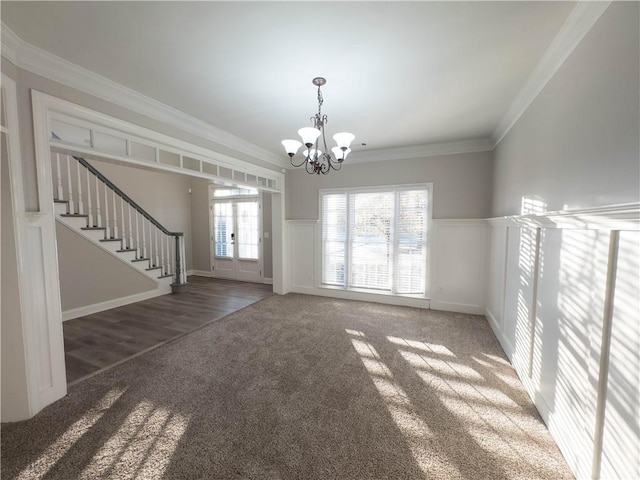 unfurnished living room with a notable chandelier, dark hardwood / wood-style flooring, and ornamental molding