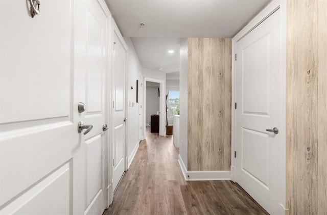 hallway featuring baseboards and wood finished floors