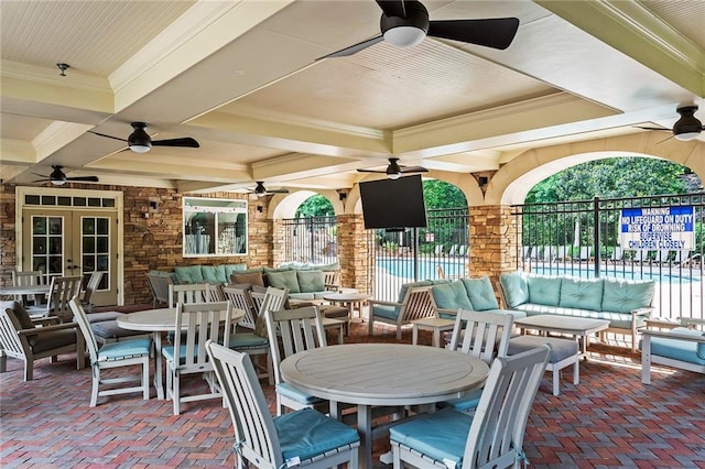 view of patio featuring fence, outdoor dining area, a community pool, french doors, and outdoor lounge area