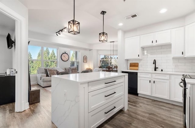 kitchen with visible vents, a sink, decorative backsplash, dishwasher, and open floor plan