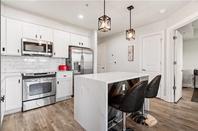 kitchen with decorative backsplash, light wood-style flooring, white cabinetry, and stainless steel appliances