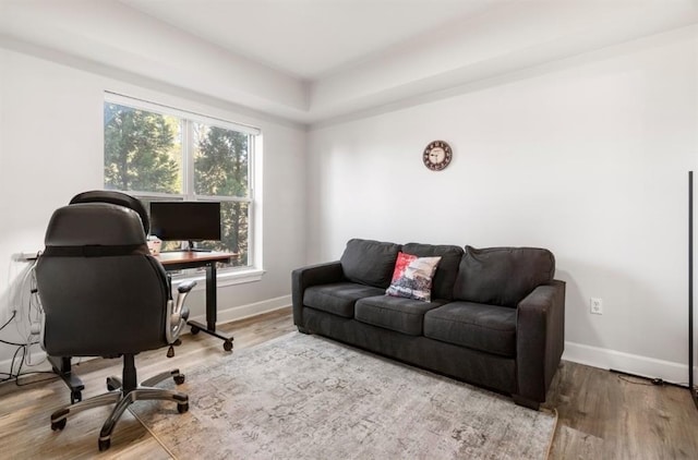 home office with baseboards and wood finished floors