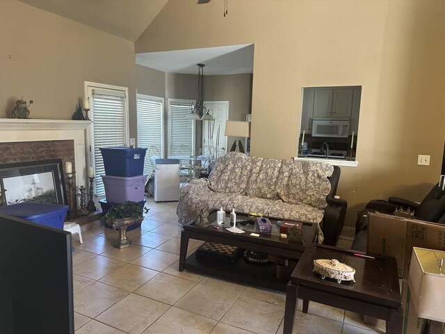 tiled living room featuring a fireplace, high vaulted ceiling, and sink