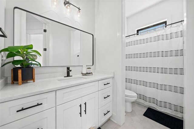 bathroom featuring a shower with curtain, vanity, toilet, and tile patterned floors