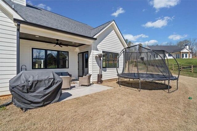 exterior space featuring a trampoline, grilling area, an outdoor hangout area, a ceiling fan, and fence