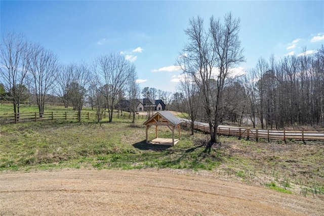 view of yard with a rural view and fence