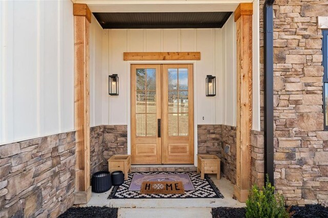 entrance to property featuring stone siding and french doors