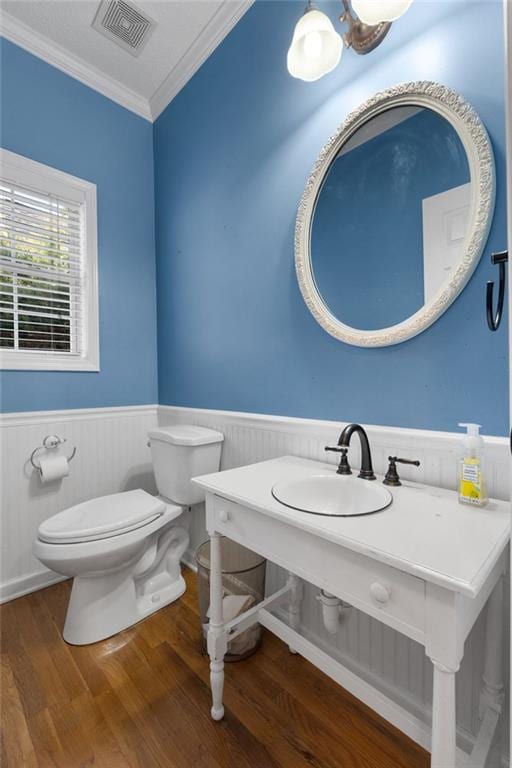 bathroom with toilet, sink, ornamental molding, and hardwood / wood-style flooring