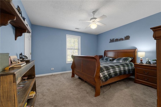 bedroom featuring ceiling fan, light colored carpet, and a textured ceiling