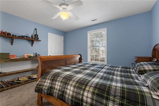 bedroom with ceiling fan, a textured ceiling, and carpet floors