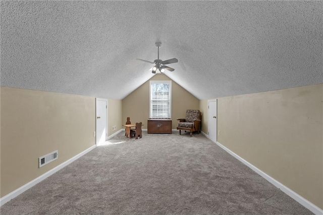 additional living space featuring ceiling fan, a textured ceiling, lofted ceiling, and carpet flooring