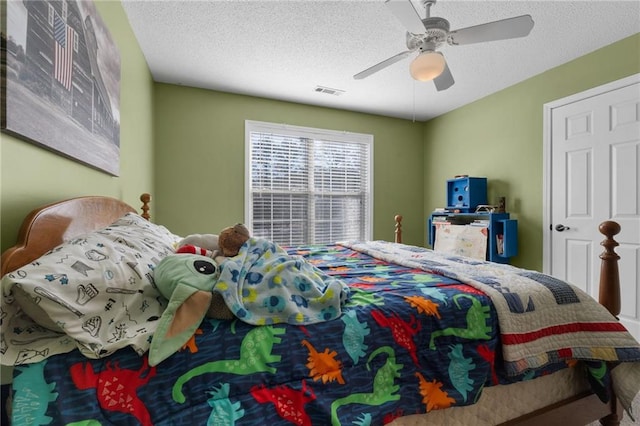 bedroom with a textured ceiling and ceiling fan