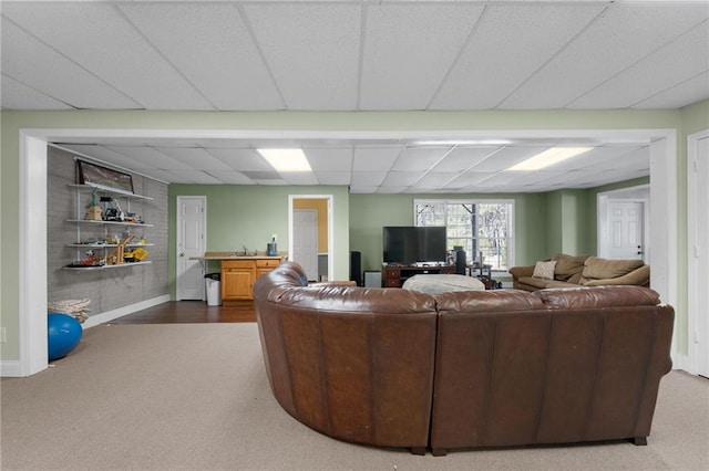 carpeted living room featuring a drop ceiling