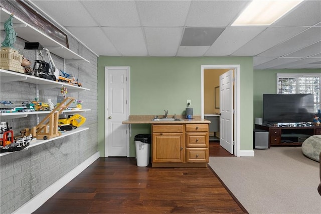 kitchen with a drop ceiling, sink, and dark carpet